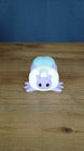 Front view of a 3D printed Palia Luna Moth plush with lavender face, white fluffy body, light blue wings, and black eyes.
