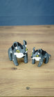 Large and small Palia Muujin collectible figurines with yellow eyes, grey bodies and black spiky manes, showing the 12 cm and 9 cm size options.