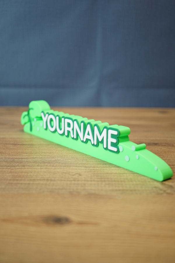 Angled view of the Palia New in Town nameplate sign showing the layered white letters, green base, and decorative gaming shelf style.