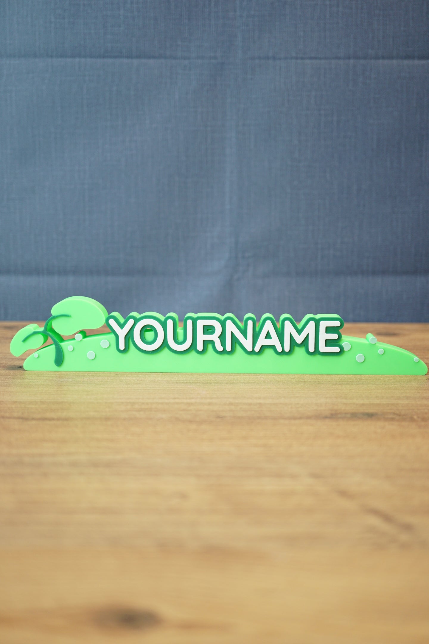 Palia New in Town nameplate sign shown from the front with green leafy details, raised white lettering, and a slim 25cm display shape.