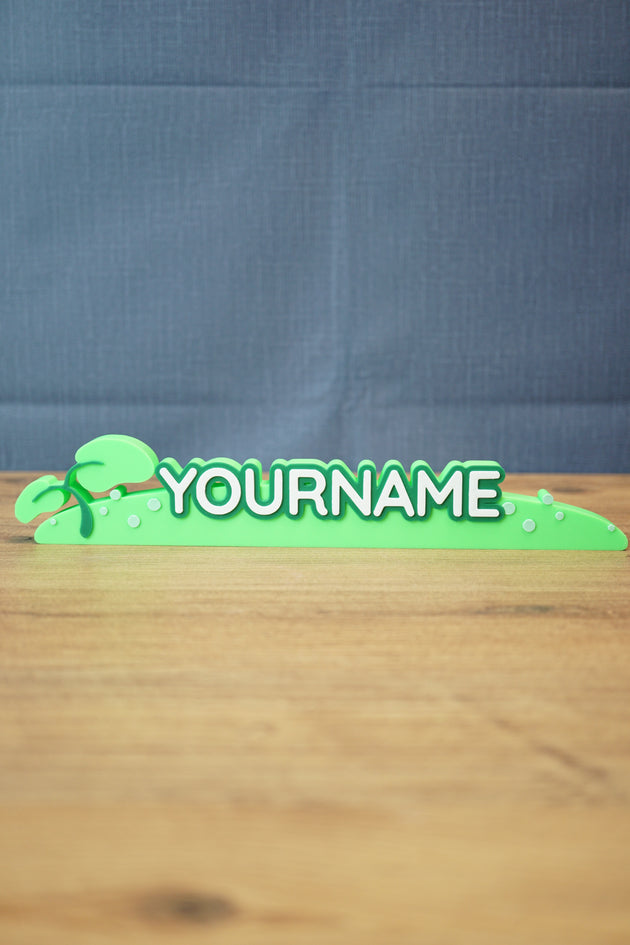 Palia New in Town nameplate sign shown from the front with green leafy details, raised white lettering, and a slim 25cm display shape.