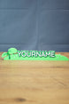 Palia New in Town nameplate sign shown from the front with green leafy details, raised white lettering, and a slim 25cm display shape.