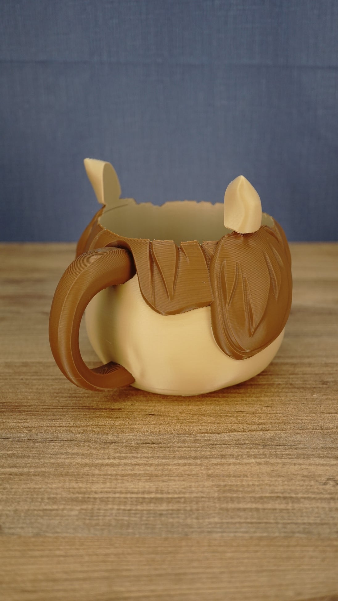 Rear side view of the Palia-inspired Ormuu ice cream holder displaying the curved carrying handle, character ear and textured brown hair details.