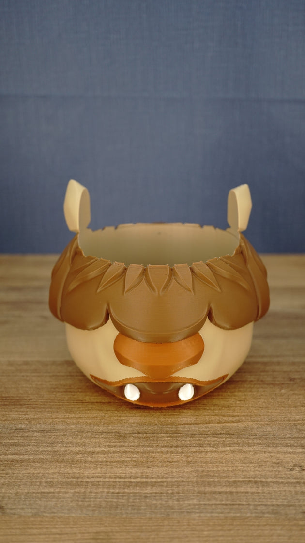 Straight-on product view of the empty Palia-inspired Ormuu holder with symmetrical ears, brown fringe, orange muzzle and two small white teeth.