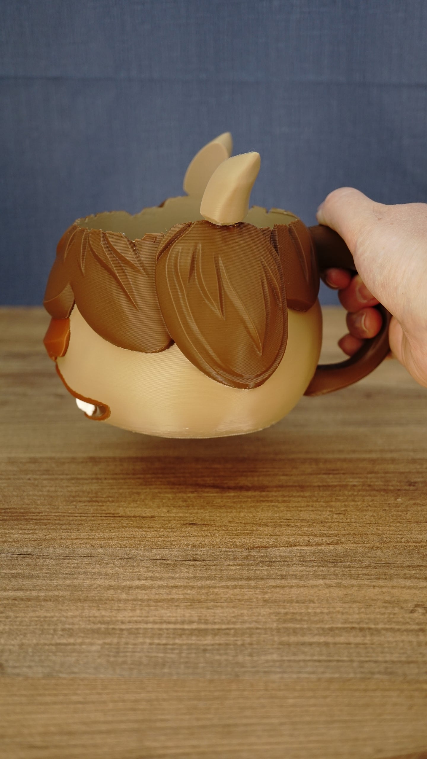 Hand holding the large curved handle of a Palia-inspired Ormuu tub holder, showing the side profile, pointed ear and layered hair design.