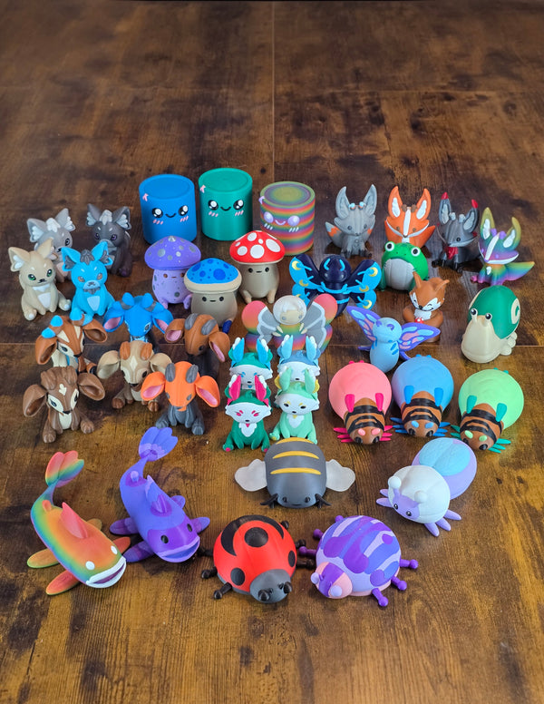 Full collection of 3D printed Palia plush figures and collectibles arranged together on a wooden floor, including Palcats, Cyls, Fun Guys, Kitsuu, Sernuk, bugs, fish, butterflies, and other colorful Palia creatures.