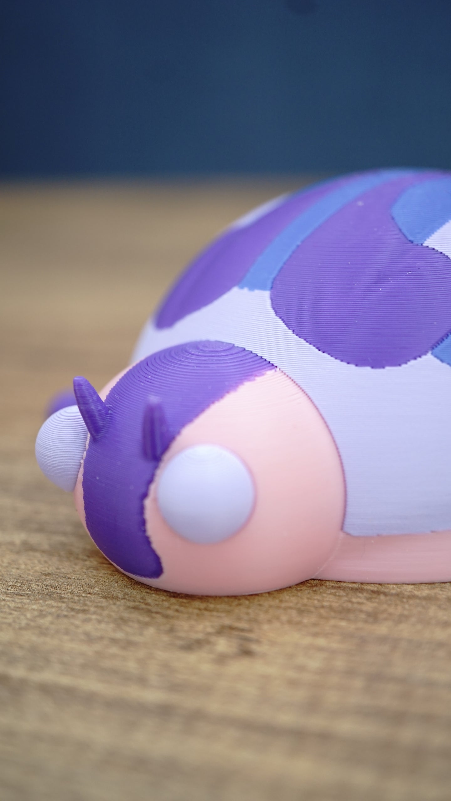 Close-up of the Palia Princess Ladybug face featuring a pink head, purple facial markings, tiny antennae and oversized white eyes