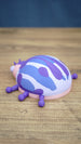 Rear side view of the Palia Princess Ladybug figure highlighting the rounded blue, white and purple patterned shell and small purple legs