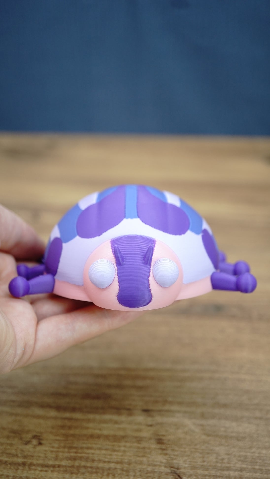 Palia Princess Ladybug collectible held in a hand to demonstrate its compact size, with pink, purple, blue and white character details visible