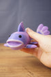 Close-up of a large purple Palia Prismfish 3D printed figure being held, showing its open mouth, fin, and lavender striped body.