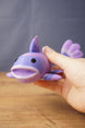 Close-up of a large purple Palia Prismfish 3D printed figure being held, showing its open mouth, fin, and lavender striped body.