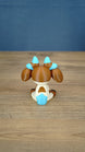 Rear view of the Proudhorned Sernuk-inspired plush figure showing cream, brown, and blue tail coloring.