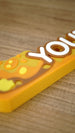Macro view of the raised lettering and layered amber artwork on a personalized Palia Royal Amber gaming desk name sign.