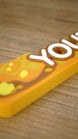 Macro view of the raised lettering and layered amber artwork on a personalized Palia Royal Amber gaming desk name sign.