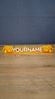 Front view of a personalized Palia Royal Amber nameplate with bold white lettering, orange and gold amber details, displayed on a wooden gaming desk.