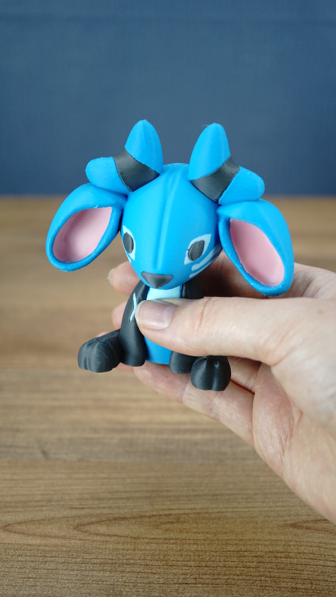 Close-up of the Royal Sernuk plush figure from Palia highlighting its blue face, pink ears, gray body, and horn details.