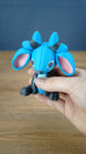 Close-up of the Royal Sernuk plush figure from Palia highlighting its blue face, pink ears, gray body, and horn details.