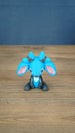 Royal Sernuk plush figure from Palia shown from the front with blue head, gray body, pink ears, and blue horns.
