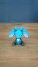 Royal Sernuk plush figure from Palia shown from the front with blue head, gray body, pink ears, and blue horns.