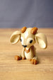 Close angled view of a Palia Sernuk figure by Created by Lou with tan colouring, brown horns, wide ears and a cute seated design.