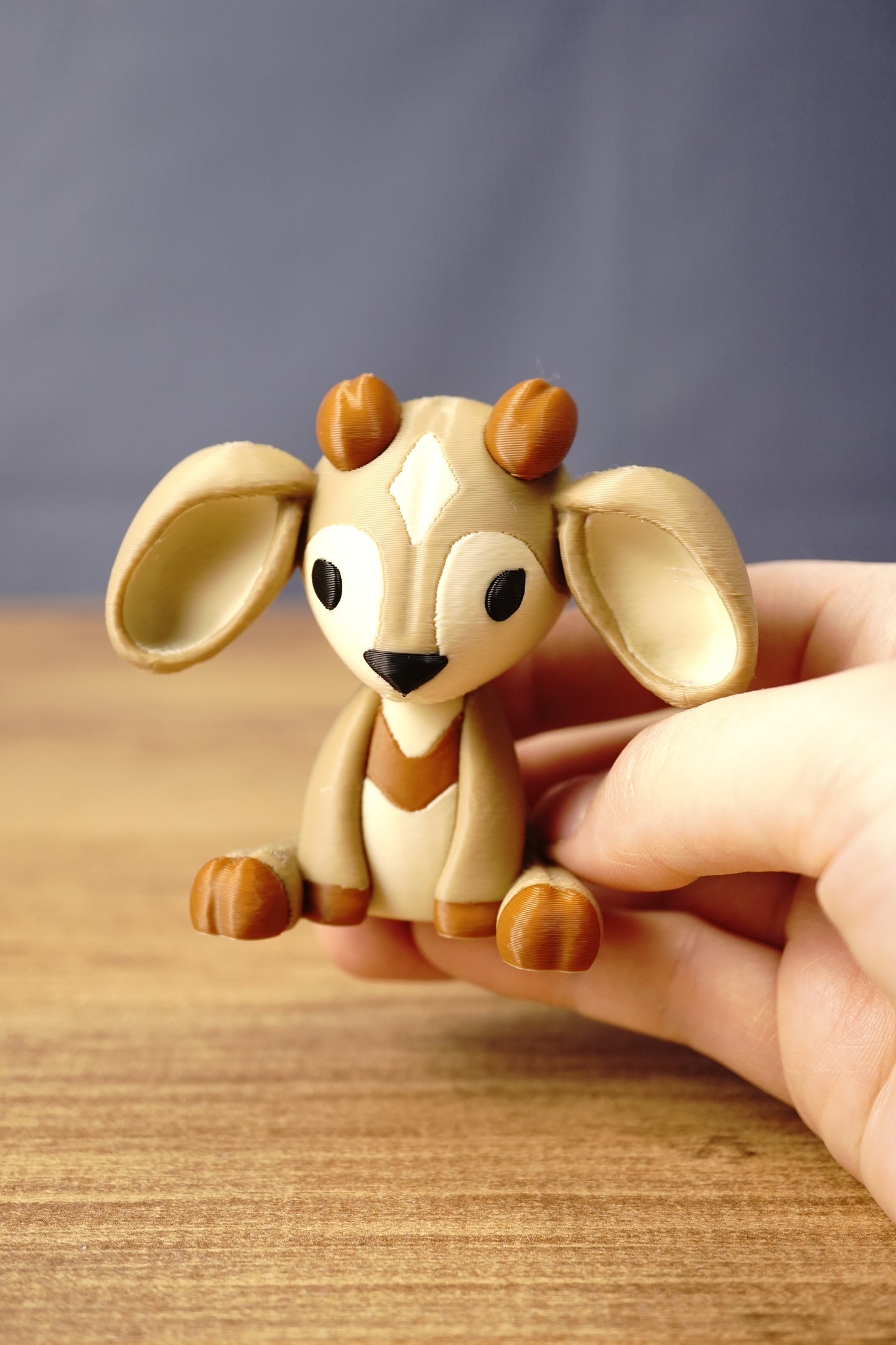 Hand holding a Palia Sernuk Plush figure by Created by Lou to show its miniature scale, detailed markings and compact size.