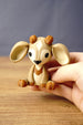 Hand holding a Palia Sernuk Plush figure by Created by Lou to show its miniature scale, detailed markings and compact size.