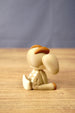 Rear side view of a Sernuk Plush figure by Created by Lou showing its curved tail, large ear and decorative white back spots.