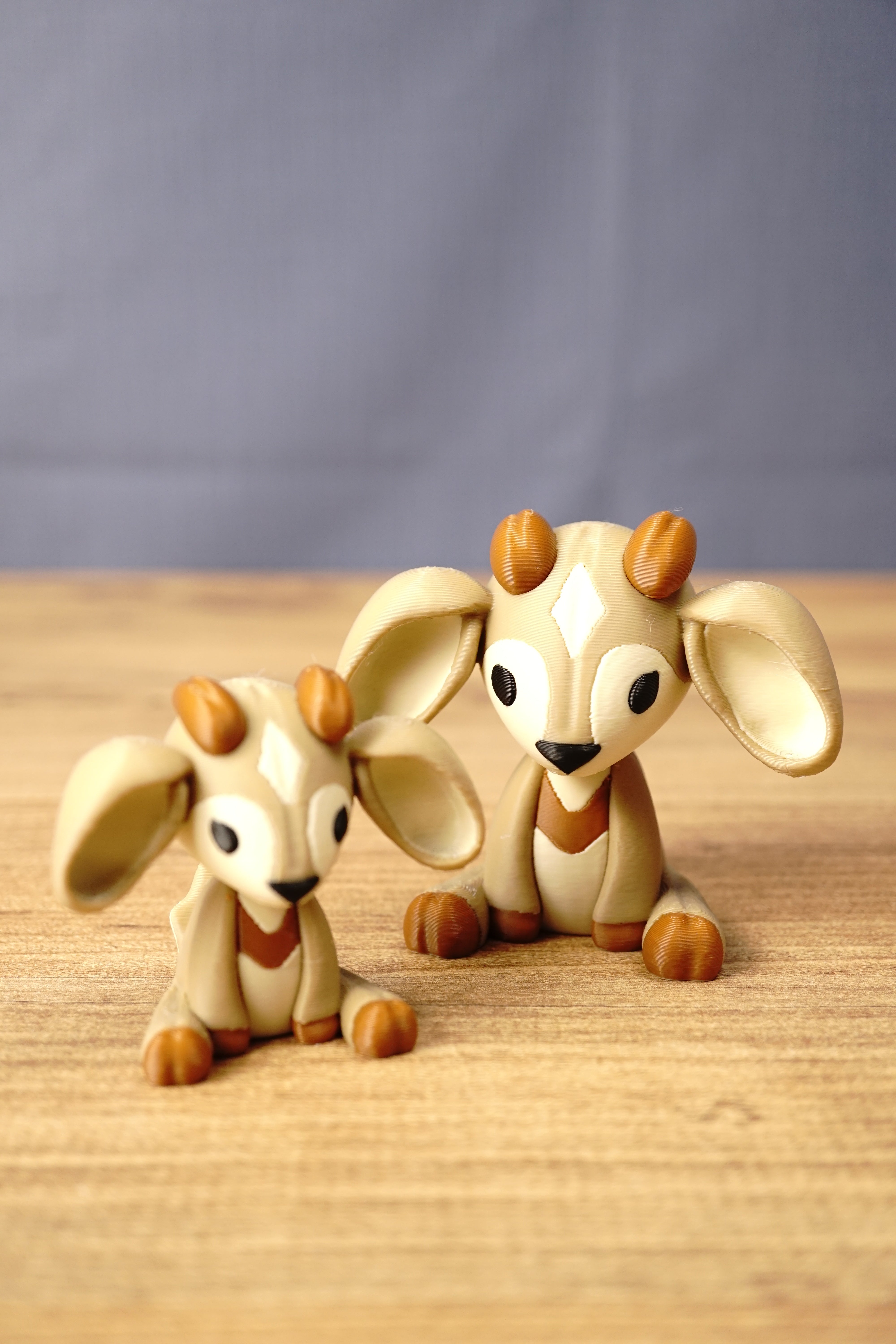 Two Palia Sernuk Plush figures by Created by Lou in 6cm and 9cm sizes displayed together on a wooden surface for size comparison.