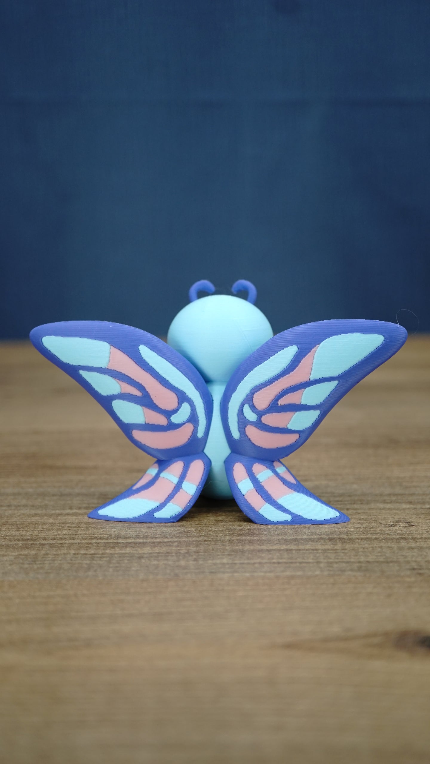 Rear view of the Palia Shimmerfly collectible figure highlighting the large symmetrical purple wings with light blue and soft pink patterned details