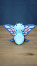 Front view of a Palia Shimmerfly Plush inspired figure with a light blue body, curled purple antennae and large decorative pink and blue wings