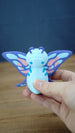 Palia Shimmerfly Plush inspired figure held in hand to show scale, with a light blue body, purple antennae and colourful butterfly-style wings