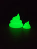 Large and small Palia SpeedyGro fertilizer collectibles glowing bright green in the dark, showing the illuminated figure and magnet styles side by side.