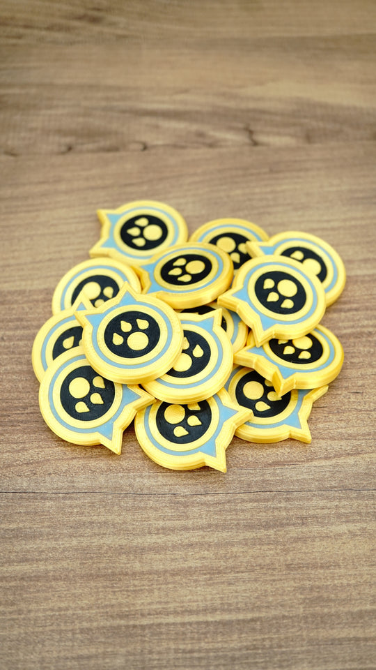 Pile of Palworld Dog Coin replica tokens on a wooden surface, showing multiple yellow, light blue and black collectible coins together.