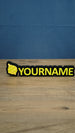 Personalised Palworld Sphere nameplate in yellow on a black base, displayed front-on on a wooden desk as custom gamer room décor with YOURNAME text.