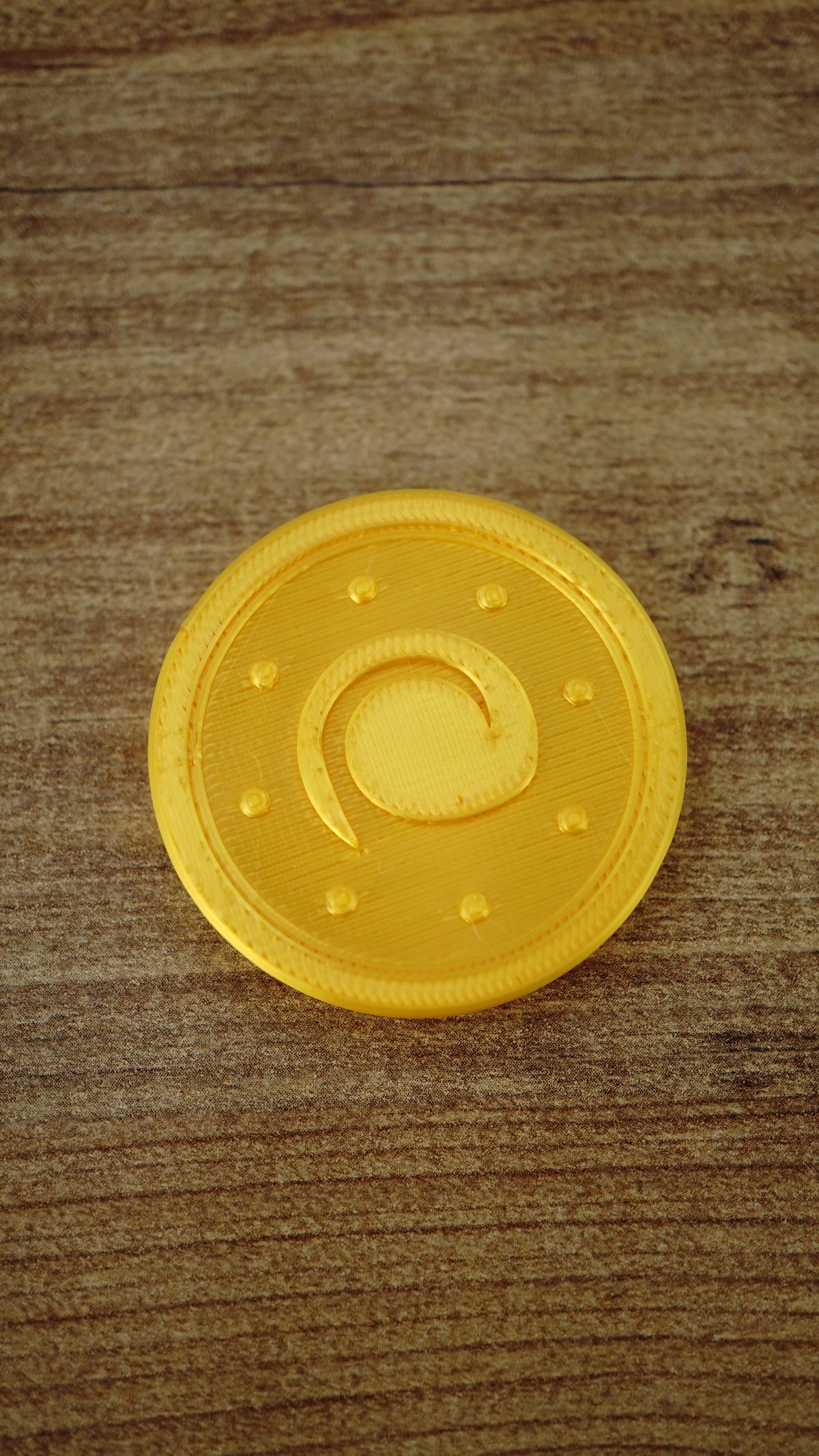 Close-up of a fan-made Palworld Gold Coin replica with a shimmering gold silk finish, approximately 4 cm in size, designed as a gaming collectible.