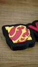 Close-up of the red and yellow Sphere emblem on a personalised Palworld gamer nameplate, highlighting the layered design on the black base.