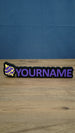 Personalised Palworld Sphere nameplate in purple and yellow on a black base, shown front-on with raised custom YOURNAME lettering for a gaming setup.