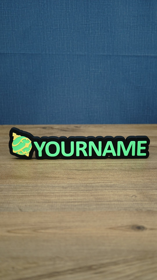 Personalised Palworld Sphere nameplate in bright green and yellow on a black base, displayed front-on as colourful gamer desk and bedroom décor.