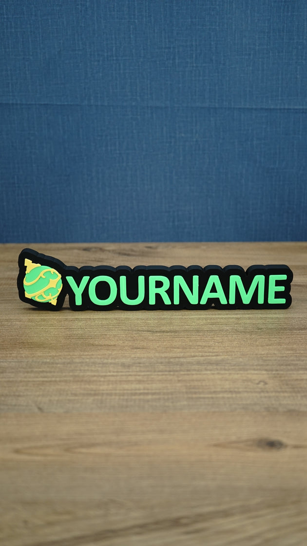 Personalised Palworld Sphere nameplate in bright green and yellow on a black base, displayed front-on as colourful gamer desk and bedroom décor.