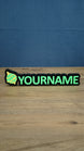 Personalised Palworld Sphere nameplate in bright green and yellow on a black base, displayed front-on as colourful gamer desk and bedroom décor.