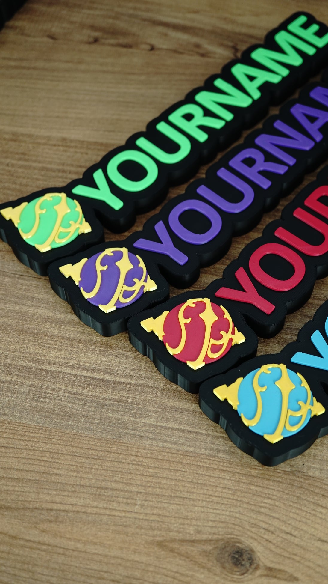 Angled group display of personalised Palworld Sphere nameplates in green, purple, red and blue, showing multiple colour options for gamer décor.