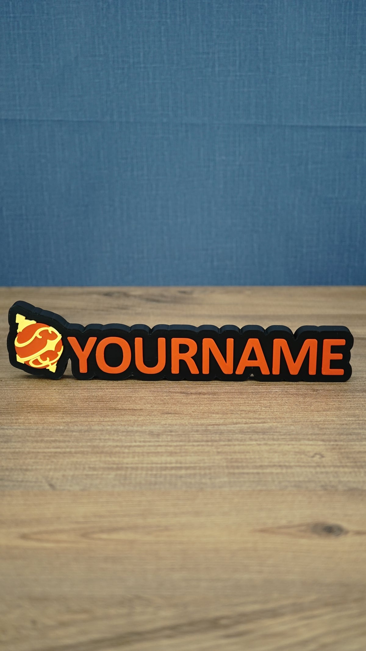 Personalised Palworld Hyper Sphere nameplate in red on a black base, shown front-on on a wooden desk with custom YOURNAME lettering.