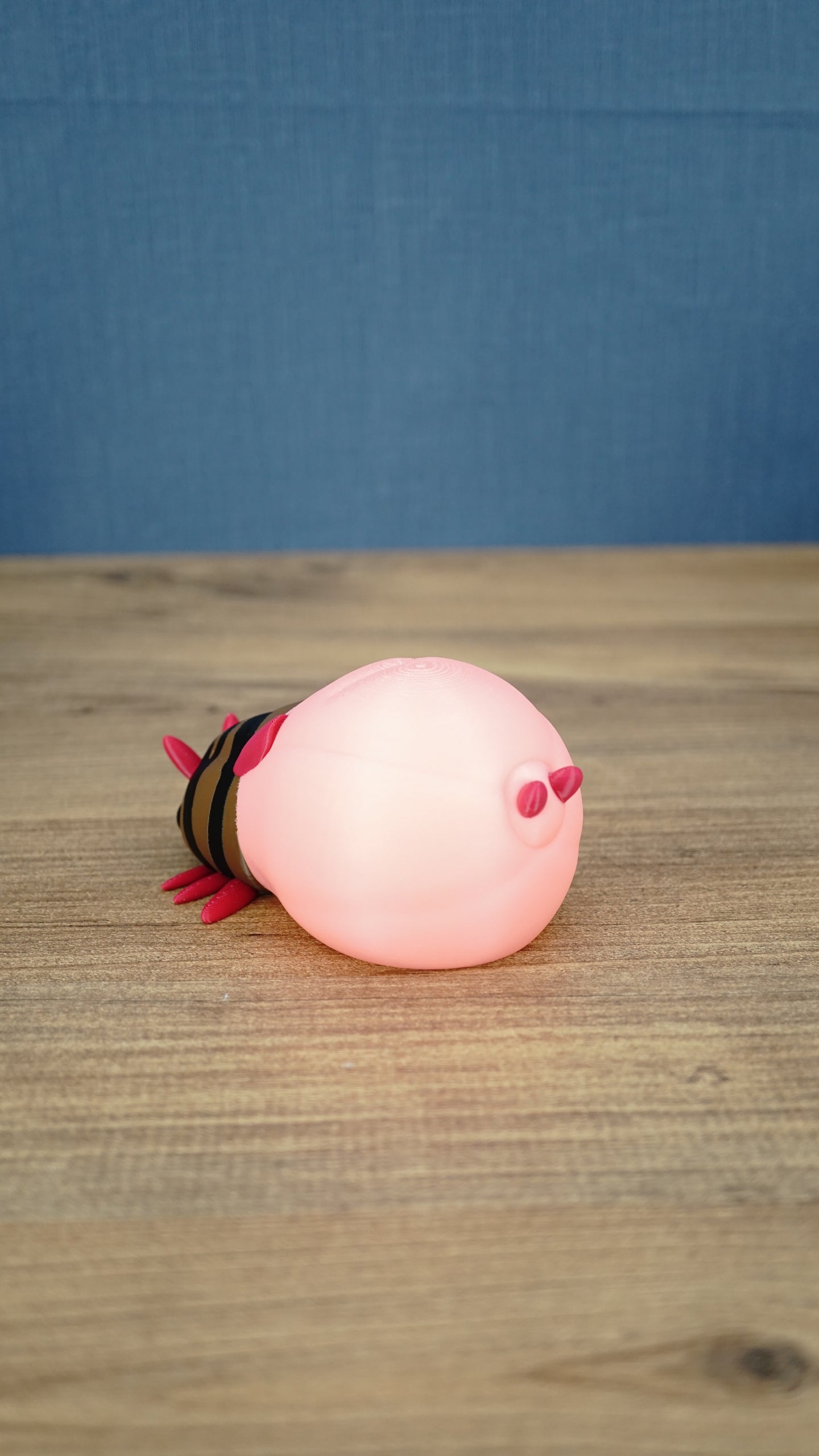 Rear view of the pink glow lantern bug plush showing its rounded pink body and tail details.