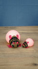 Large and small pink Palia-inspired lantern bug plush figures displayed together on a wooden tabletop.