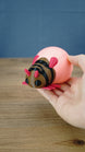 Hand holding a pink Palia-inspired lantern bug plush figure to show its size and shape.