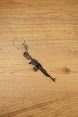 Close-up angled PKM rifle keyring with detailed LMG shape, metal chain and key ring, made for FPS fans and gaming gift collections