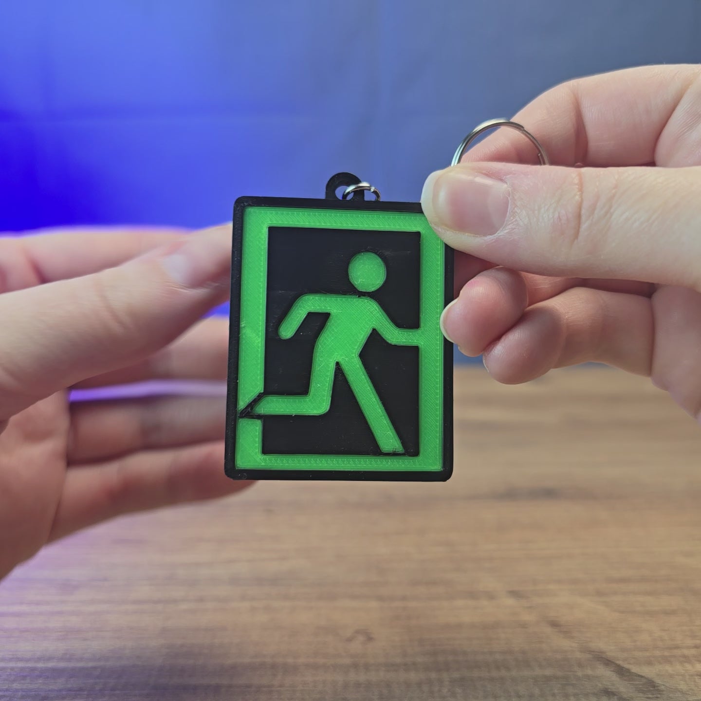 Glow-in-the-dark Escape from Tarkov extraction keyring shown being held and rotated by hand, designed as a gaming accessory, collectible, or gift for Tarkov fans.