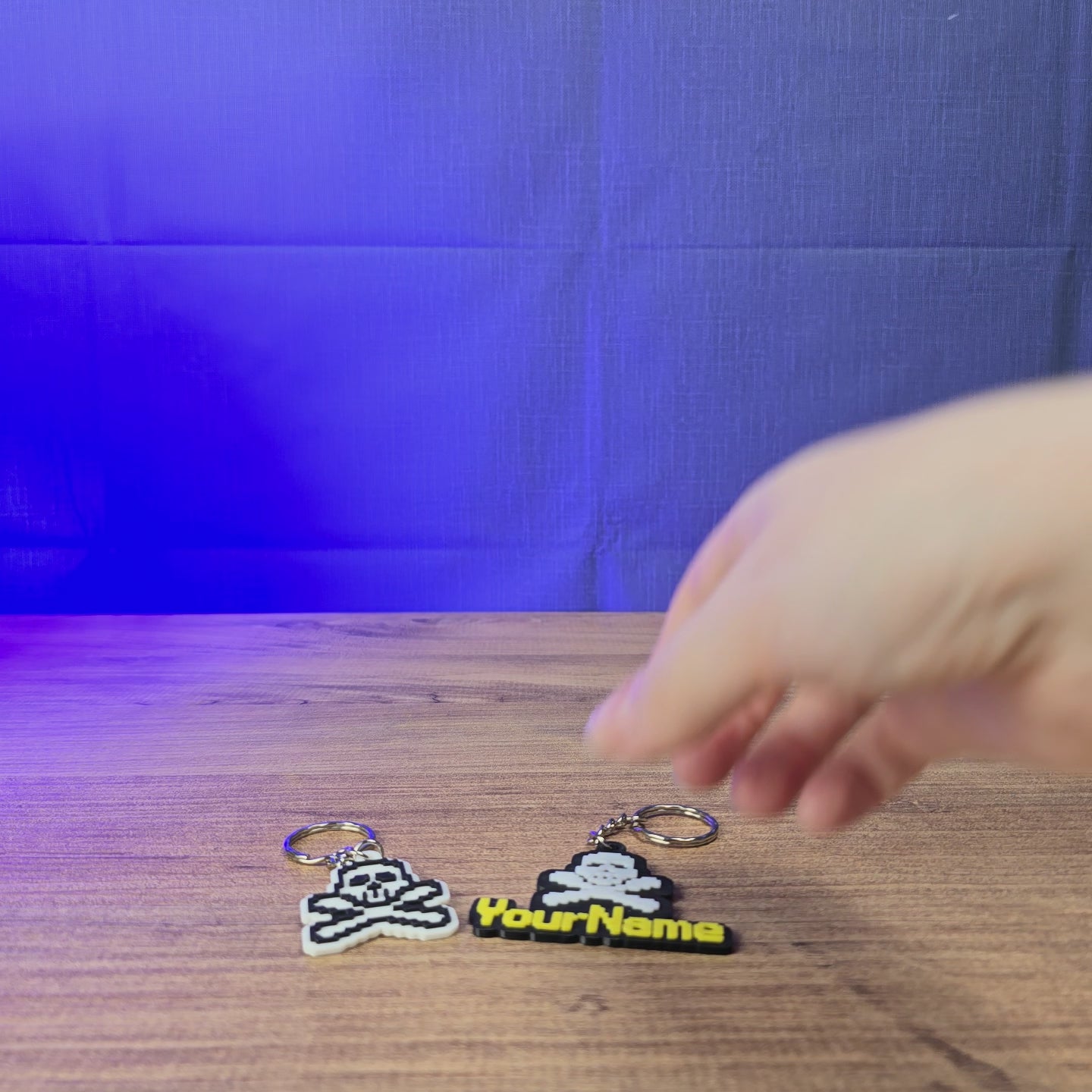 3D-printed RuneScape PK skull keyring shown being held and rotated by hand, with a personalised name option for OSRS fans.