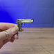 Desert Eagle pistol keychain replica shown being held and rotated by hand, designed as a miniature pistol-inspired accessory or keyring.