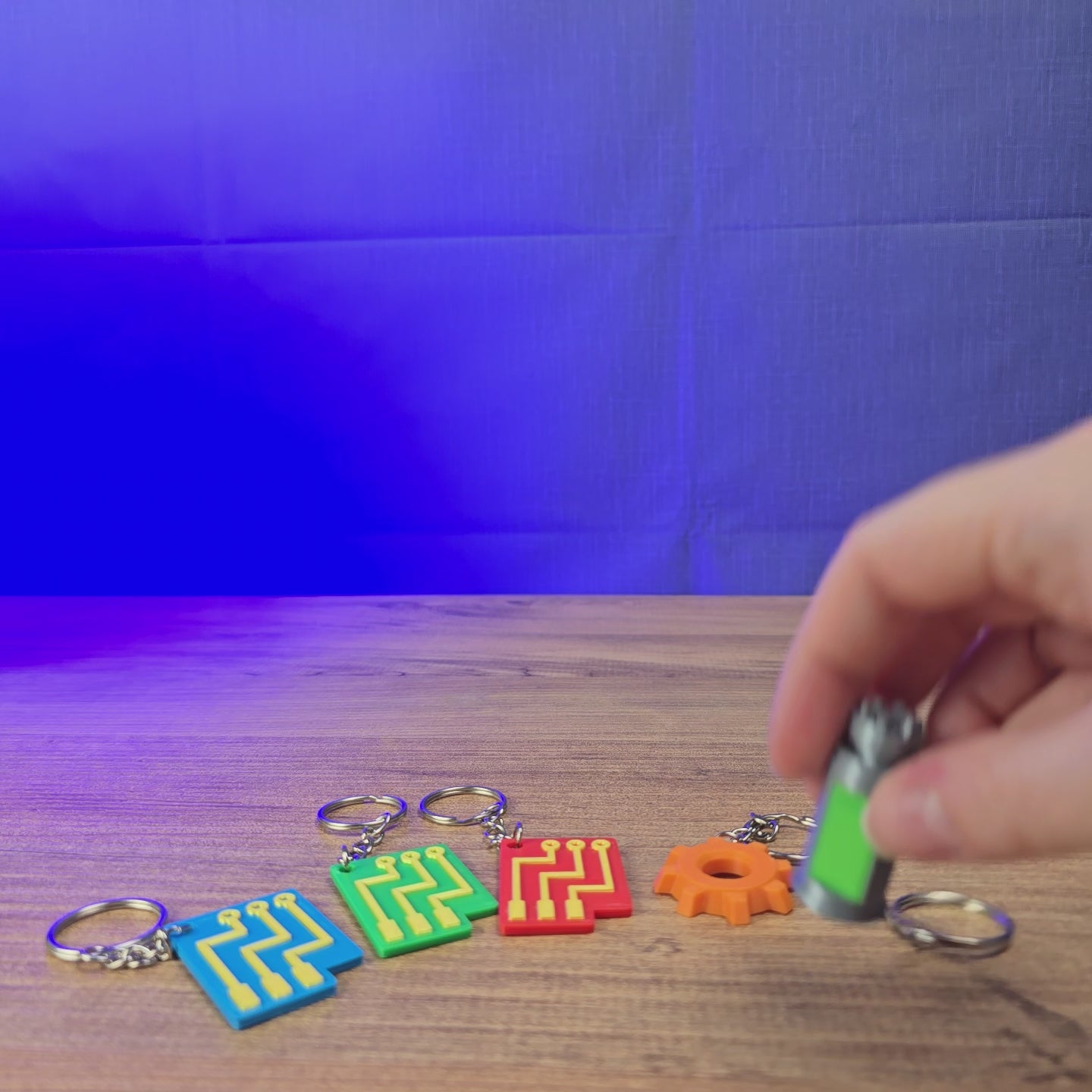 3D-printed Factorio-inspired keyrings shown being held and displayed, featuring multiple game-themed designs for Factorio fans and gaming setups.